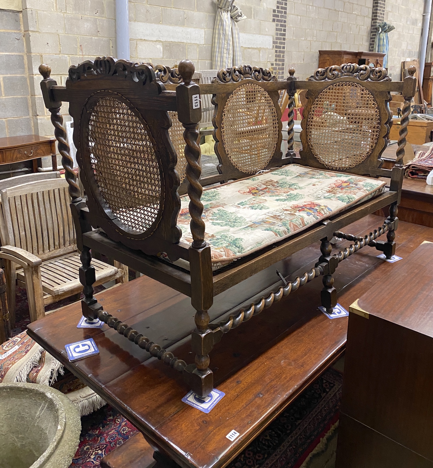 An early 20th century Jacobean revival caned oak settee, width 146cm, depth 65cm, height 95cm